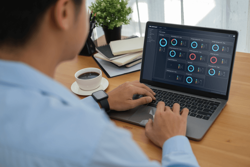 Image of a person sitting at a desk working on a laptop with PKI Spotlight on the screen.